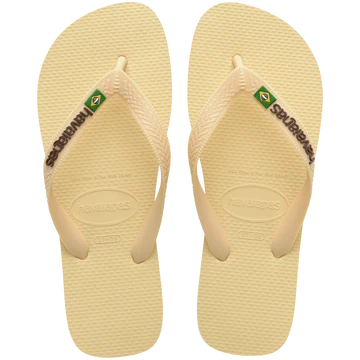 light yellow flip flops with yellow straps that say havaianas in brown, and a brazil flag, top view